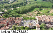 Panoramic aerial view of medieval walled village of Hostalric with reddish tiled roofs of residential buildings on summer day, Catalonia, Spain. Стоковое видео, видеограф Яков Филимонов / Фотобанк Лори