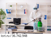 Old male contractor in office disinfection concept. Стоковое фото, фотограф Elnur / Фотобанк Лори
