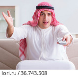 Arab man watching tv at home. Стоковое фото, фотограф Elnur / Фотобанк Лори