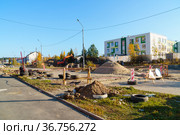 Огорожен перекопанный участок автодороги для проведения работ по прокладке труб и кабелей к построенному детскому садику в городе (2021 год). Стоковое фото, фотограф Sergei Gorin / Фотобанк Лори