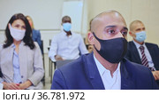Side view of managers group in protective masks working at laptops in company office. Стоковое видео, видеограф Яков Филимонов / Фотобанк Лори