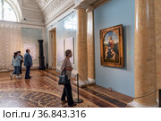 Женщина смотрит на картину Рафаэля Санти из Музея Лувра «Прекрасная садовница» – «Мадонна с Младенцем и Иоанном Крестителем». Государственный Эрмитаж. Санкт-Петербург (2021 год). Редакционное фото, фотограф Румянцева Наталия / Фотобанк Лори