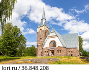 Old church kirk Raislya designed by architect Joseph Stenback in 1912 in style of Finnish national romanticism, northern variety of Art Nouveau in sunny summer day. Melnikovo, Leningrad region, Russia. Стоковое фото, фотограф Алексей Ширманов / Фотобанк Лори