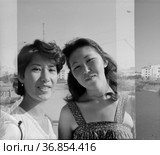 Портрет двух студенток в летней одежде, позирующих на фоне города, молодые женщины улыбаются и смотрят в камеру, лица привлекательных девушке крупным планом, Якутия, Якутский технологический университет. Редакционное фото, фотограф Варфоломей Тетерин / Фотобанк Лори