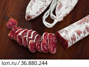 Slicing delicious Spanish smoked sausage fuete. Стоковое фото, фотограф Яков Филимонов / Фотобанк Лори