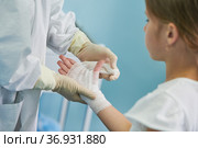 surgeon doctor bandaging child's hand in clinic. Стоковое фото, фотограф Дмитрий Калиновский / Фотобанк Лори