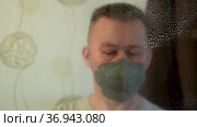 Крупно портрет мужчины в респираторной маске и перчатках дезинфицирует поверхность окна спреем и тряпкой. Стоковое видео, видеограф Sergei Gorin / Фотобанк Лори