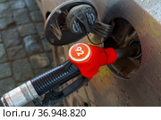 Заправочный пистолет с маркировкой АИ-92 в бензобаке автомобиля на АЗС. Стоковое фото, фотограф Sergei Gorin / Фотобанк Лори