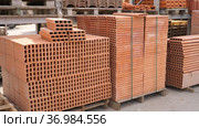 Pallets with stack of redbricks lying at warehouse of building materials in sunny day. Стоковое видео, видеограф Яков Филимонов / Фотобанк Лори