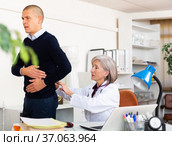Senior woman nephrologist examining patient complaining of kidneys pain. Стоковое фото, фотограф Яков Филимонов / Фотобанк Лори