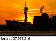 Силуэт ледокола на фоне заката. Пар от воды во время сильного мороза. Стоковое фото, фотограф Яковлев Сергей / Фотобанк Лори