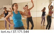 Portrait of cheerful girl practicing vigorous jive movements in group dance class. Стоковое видео, видеограф Яков Филимонов / Фотобанк Лори