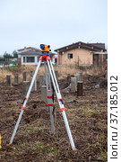 Theodolite stands on a tripod in the middle of the construction site, foundation works. Стоковое фото, фотограф Кекяляйнен Андрей / Фотобанк Лори