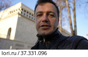 Businessman standing outdoors with office building, looking at camera, explaining and talking. Стоковое видео, видеограф Данила Большаков / Фотобанк Лори