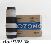 Упаковочная коробка фирмы Ozon и фотообъектив (2022 год). Редакционное фото, фотограф Евгений Будюкин / Фотобанк Лори