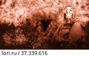 A shot of a man dressed in a gas mask, a hooded jacket, a backpack, crossed his arms on his chest, looking into the camera. background grunge. Стоковое фото, фотограф Владимир Арсентьев / Фотобанк Лори