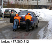 Молодые люди толкают заглохший на дороге автомобиль. Новосибирская улица. Район Гольяново. Город Москва (2013 год). Редакционное фото, фотограф lana1501 / Фотобанк Лори
