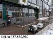 Два ровера доставки еды «Яндекс» возле ресторана «Макдоналдс» (McDonald’s). Город Мурино Всеволожского района Ленинградской области (2022 год). Редакционное фото, фотограф Румянцева Наталия / Фотобанк Лори