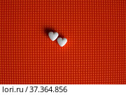 Two heart-shaped tablets lie on a textured surface. Стоковое фото, фотограф Александр Клёнов / Фотобанк Лори