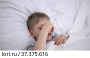 The sick boy lies in bed. High body temperature. The child has a cold. Coronavirus infection omicron. Flu. Treatment at home. Hospital for childcare. Child has a headache. Home quarantine. Стоковое видео, видеограф Ирина Ткачук / Фотобанк Лори