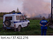 Сотрудники полиции прибыли на место происшествия. Горят деревянные дома в деревне Ранцево Тверской области. Police officers arrived at the scene. A fire in the village. Burning wooden houses in the village of Rantsevo, Tver region. (2021 год). Редакционное фото, фотограф Мария / Фотобанк Лори