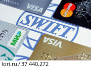 Банковские карты VISA, MasterCard, "Мир" на фоне логотипа SWIFT (2022 год). Редакционное фото, фотограф Гребенев Пётр / Фотобанк Лори