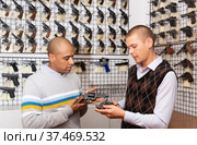 Two men choosing sporting and hunting revolvers in gunsmith shop. Стоковое фото, фотограф Яков Филимонов / Фотобанк Лори
