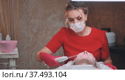 A beautician makes a darsonvalization of the face of a young girl with problem skin. Стоковое видео, видеограф Mikhail Davidovich / Фотобанк Лори