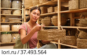 Asian woman standing and choosing wicker basket in housewares store. Стоковое видео, видеограф Яков Филимонов / Фотобанк Лори