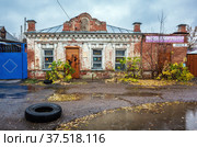 Sovetskaya street, Orenburg, Russia - October, 24, 2021: The old building of the former store for sale. Autumn rain. Редакционное фото, фотограф Вадим Орлов / Фотобанк Лори