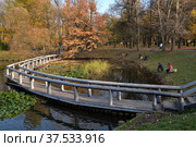 Upper pond with wooden bridge of cascade of ponds in natural historical, architectural and recreational complex "Vorontsovo Estate" of 18th century, Vorontsov Park in autumn, Moscow, Russia (2021 год). Редакционное фото, фотограф Алексей Антипов / Фотобанк Лори