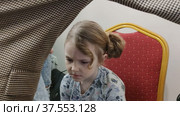 Стилист делает модную красивую прическу ребенку. The stylist makes a fashionable beautiful hairstyle for the child. Стоковое видео, видеограф Мария / Фотобанк Лори