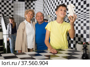 Kids solving riddles in escape room and grandparents watching them. Стоковое фото, фотограф Яков Филимонов / Фотобанк Лори