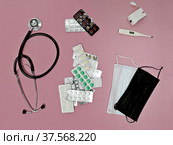 Стетоскоп, пульсоксиметр, медицинские маски, таблетки, градусник на розовом фоне. Стоковое фото, фотограф Ludmila Zyubina / Фотобанк Лори