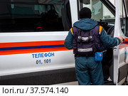 Сотрудник МЧС России садится в автомобиль специальной службы в городе Москве, Россия (2022 год). Редакционное фото, фотограф Николай Винокуров / Фотобанк Лори