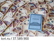 Сберкнижка Сбербанка Российской Федерации лежит на пятисотрублёвых купюрах (2022 год). Редакционное фото, фотограф Владимир Устенко / Фотобанк Лори