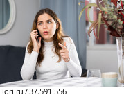 Wrathful woman quarreling on phone in apartment. Стоковое фото, фотограф Яков Филимонов / Фотобанк Лори