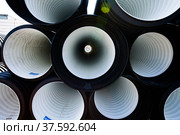 Plastic pipes production plant warehouse. Black and white PVC channelled pipes. Стоковое фото, фотограф Alexey Rezvykh / Фотобанк Лори