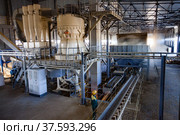 Aktobe region, Kazakhstan - May 04 2019: Phosphate fertilizers plant. Pellets producing machine of full circle. Operator controls process. Редакционное фото, фотограф Alexey Rezvykh / Фотобанк Лори