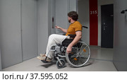 Man in a wheelchair rolling to an elevator and press the button. Стоковое видео, видеограф Константин Шишкин / Фотобанк Лори