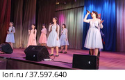 На сцене подростки исполняют песню. On stage, teenagers perform a song. Редакционное видео, видеограф Мария / Фотобанк Лори