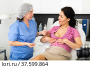 Woman asking cosmetologist about breast lift and reshaping procedures. Стоковое фото, фотограф Яков Филимонов / Фотобанк Лори