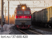 Советский электровоз ВЛ80т-1945 и встречный поезд мартовским вечером. Северная железная дорога (2022 год). Редакционное фото, фотограф Виктор Карасев / Фотобанк Лори
