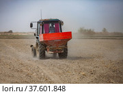 Kyzylorda Province, Kazakhstan - May 01, 2019. Tractor seeds rice in farmer's field. Spring sowing campaign. Редакционное фото, фотограф Alexey Rezvykh / Фотобанк Лори