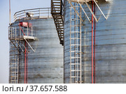 Oil refinery and gas processing plant warehouse. Close-up of galvanizing steel storage tanks on grey sky background. Taraz city, Kazakstan. Стоковое фото, фотограф Alexey Rezvykh / Фотобанк Лори