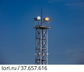 Lighting mast with floodlight at oil refinery plant against blue sky background. Стоковое фото, фотограф Alexey Rezvykh / Фотобанк Лори