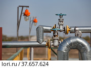 Oil refinery plant in desert. Valve armature and pipes on grey sky background. Focus on foreground. Стоковое фото, фотограф Alexey Rezvykh / Фотобанк Лори
