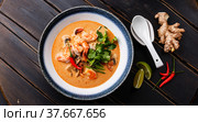 Tom Yam kung Spicy Thai soup with shrimp, seafood, coconut milk and chili pepper in bowl. Стоковое фото, фотограф Лисовская Наталья / Фотобанк Лори