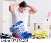 Man doing laundry at home. Стоковое фото, фотограф Elnur / Фотобанк Лори