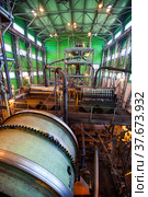 Gold ore Concentrating plant. Ball mill on front. Gold gravity spiral chute concentrator (ore spiral) and wet magnetic drum separators on background (2012 год). Редакционное фото, фотограф Alexey Rezvykh / Фотобанк Лори